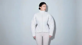 Layering for fall with a structured white puffer jacket styled over fitted beige leggings.