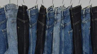 Best jeans for women displayed in various blue and black denim washes hanging neatly on hangers.