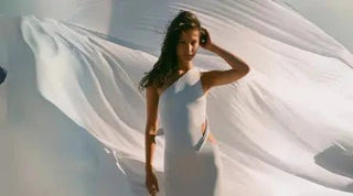 Casual winter dress in white with an asymmetrical cut, flowing elegantly in the wind