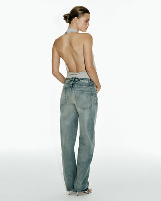 MODEL POSING IN GREY HALTER TOP AND JEANS