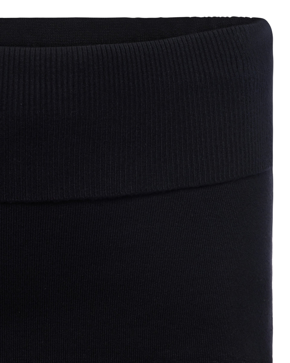Mini skort in black ribbed knit fabric with wide waistband detail shown in close-up view.