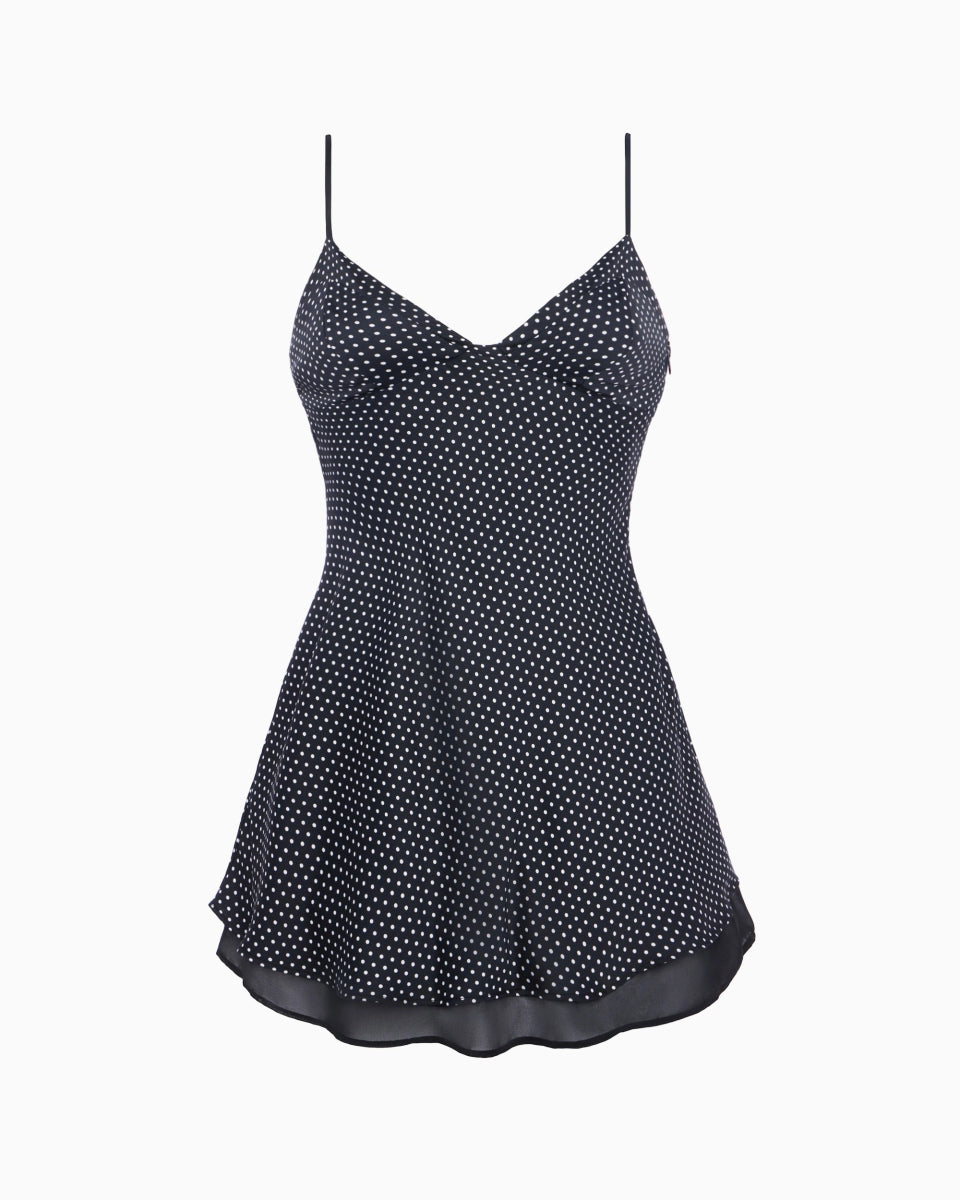 Polka dot mini dress with thin spaghetti straps, fitted bodice, and flared hemline in black and white pattern.